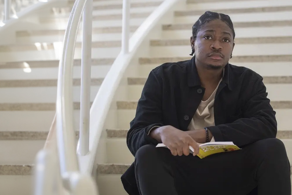 Micah White sits on a staircase