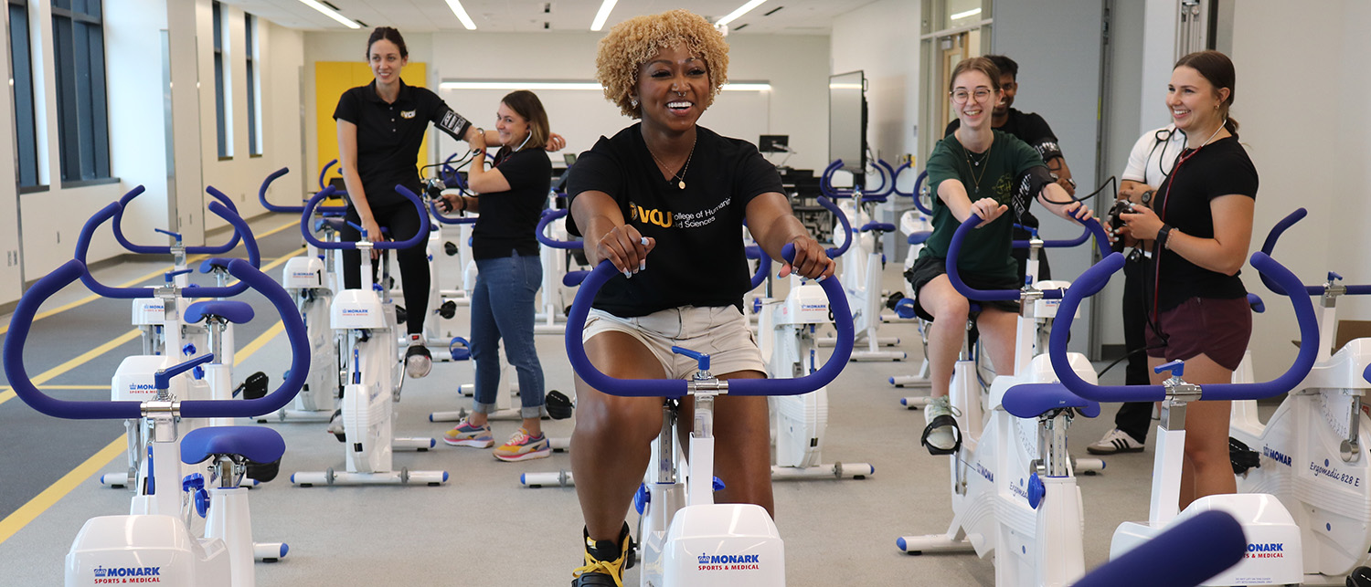 Students test out stationary bikes in the STEM Building exercise lab