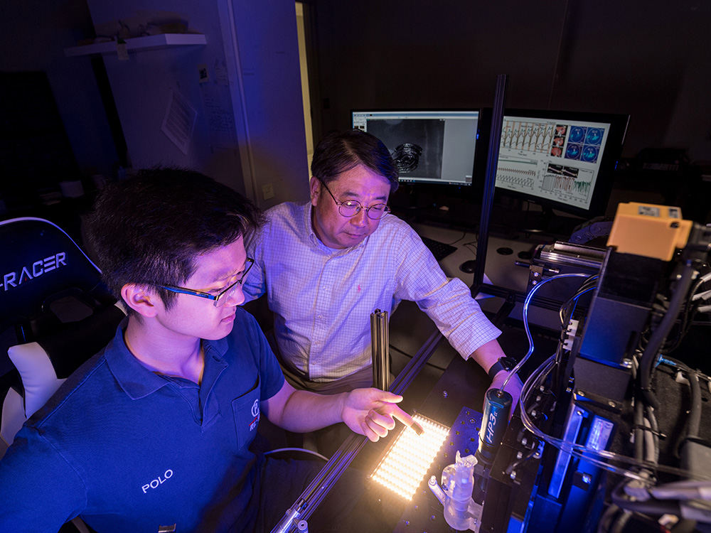 Andy Shar, left, and Daeha Joung, Ph.D., center, inspect the flexible 3D printing ink