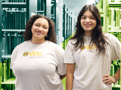 Emma Coffey (left) and Liz Zepeda-Cantarero standing in front of library bookshelves