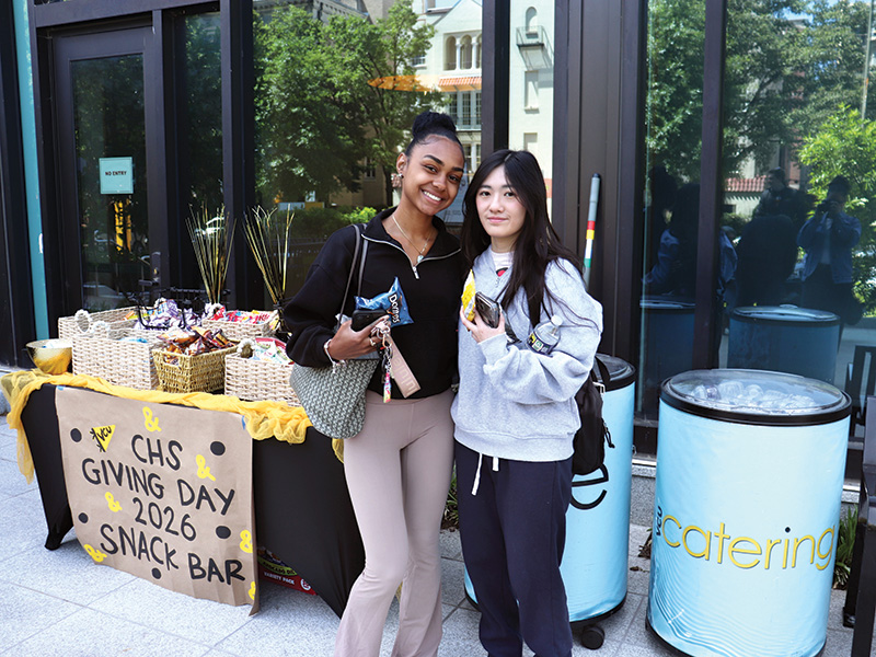 Two students stand in front of a snack table on VCU Giving Day