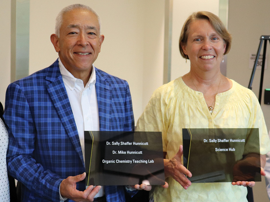 Drs. Mike and Sally Hunnicutt hold new room plaques for spaces named for them in the STEM Building.