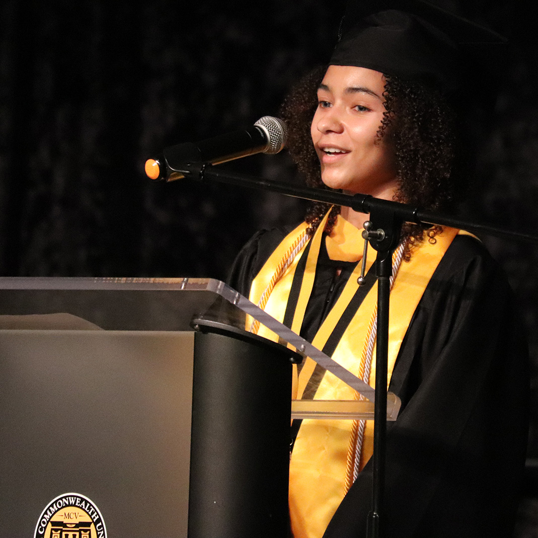 A student speaks at the podium during graduation