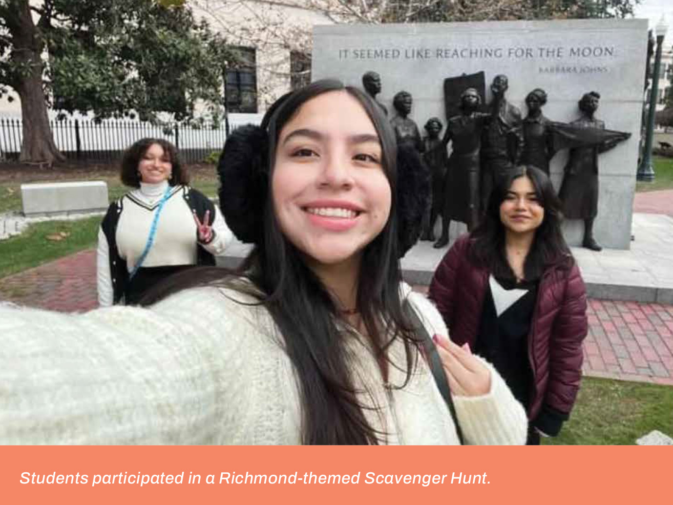 Students posing in front of a monument with a caption that reads, 