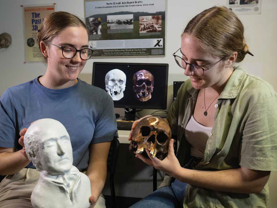 Gabby Carter (left), holds a 3D-printed bust of Charles Willson Peale while Anna Carter holds the skull of John Barber, the so-called “Connecticut Vampire