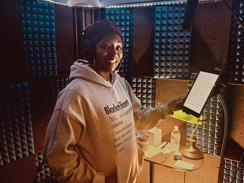 Grace Gipson holds up a tablet in a recording studio