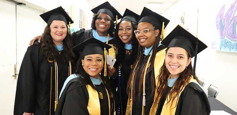 a group of happy v.c.u. students posing in their commencement regalia