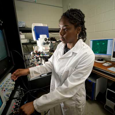 a researcher making adjustments to equipment in a research lab
