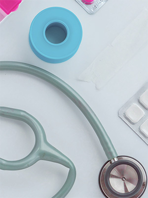 a stethoscope, keyboard and roll of medical tape sitting on a white table