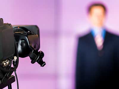 a video camera filming a news anchor