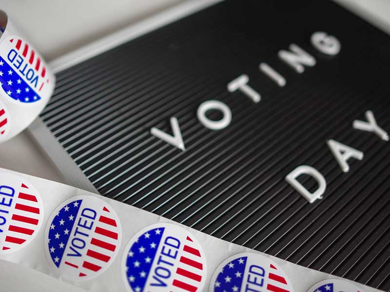 bulletin board that says 'voting day' with stickers that read 'i voted'