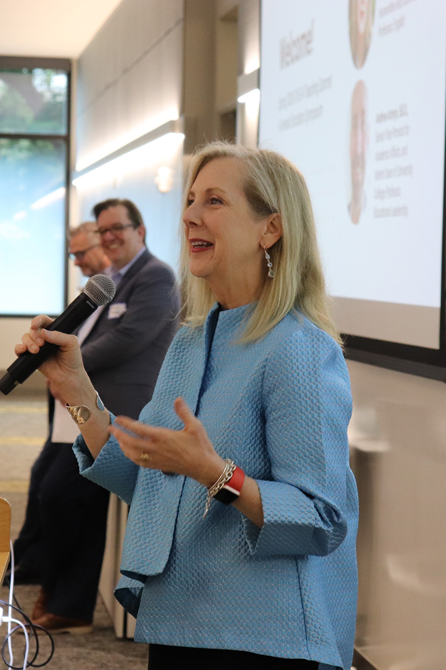 Dean Catherine Ingrassia speaks in front of a conference room