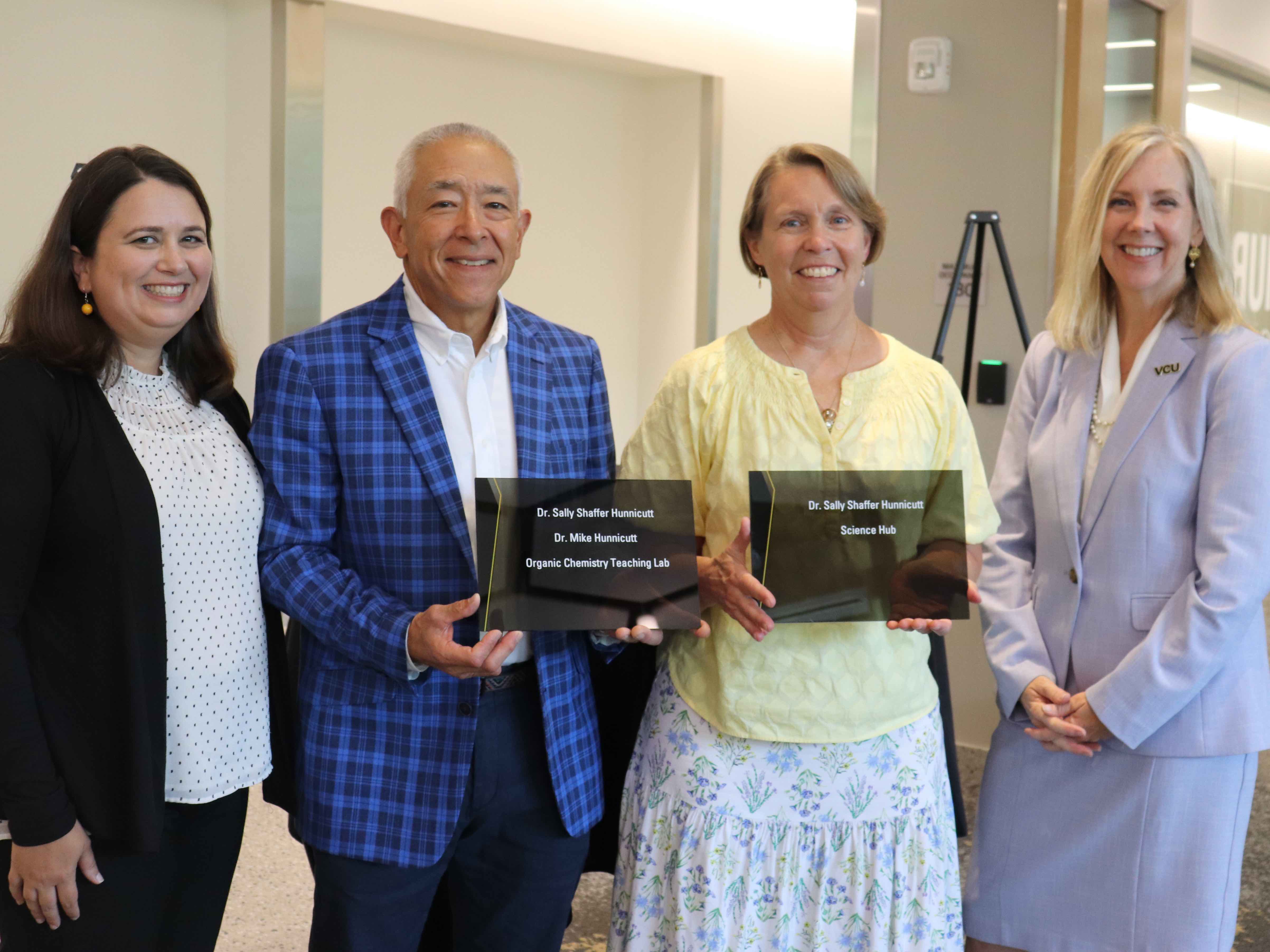 Four people posing with naming plaques - Michal Coffey, Mike and Sally Hunnicutt, and Catherine Ingrassia