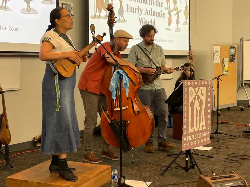 a three-person band giving a performance on stage