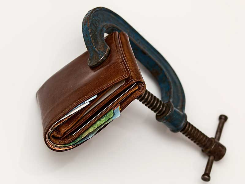 a wallet being squeezed by a clamp