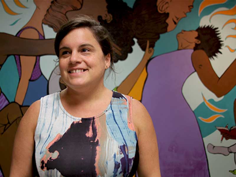 elizabeth canfield in front of a vibrant mural
