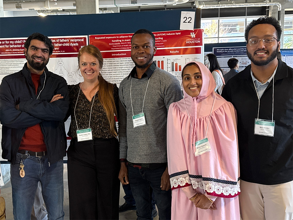 Heather Caslin, second from left, poses with four individuals in front of research posters